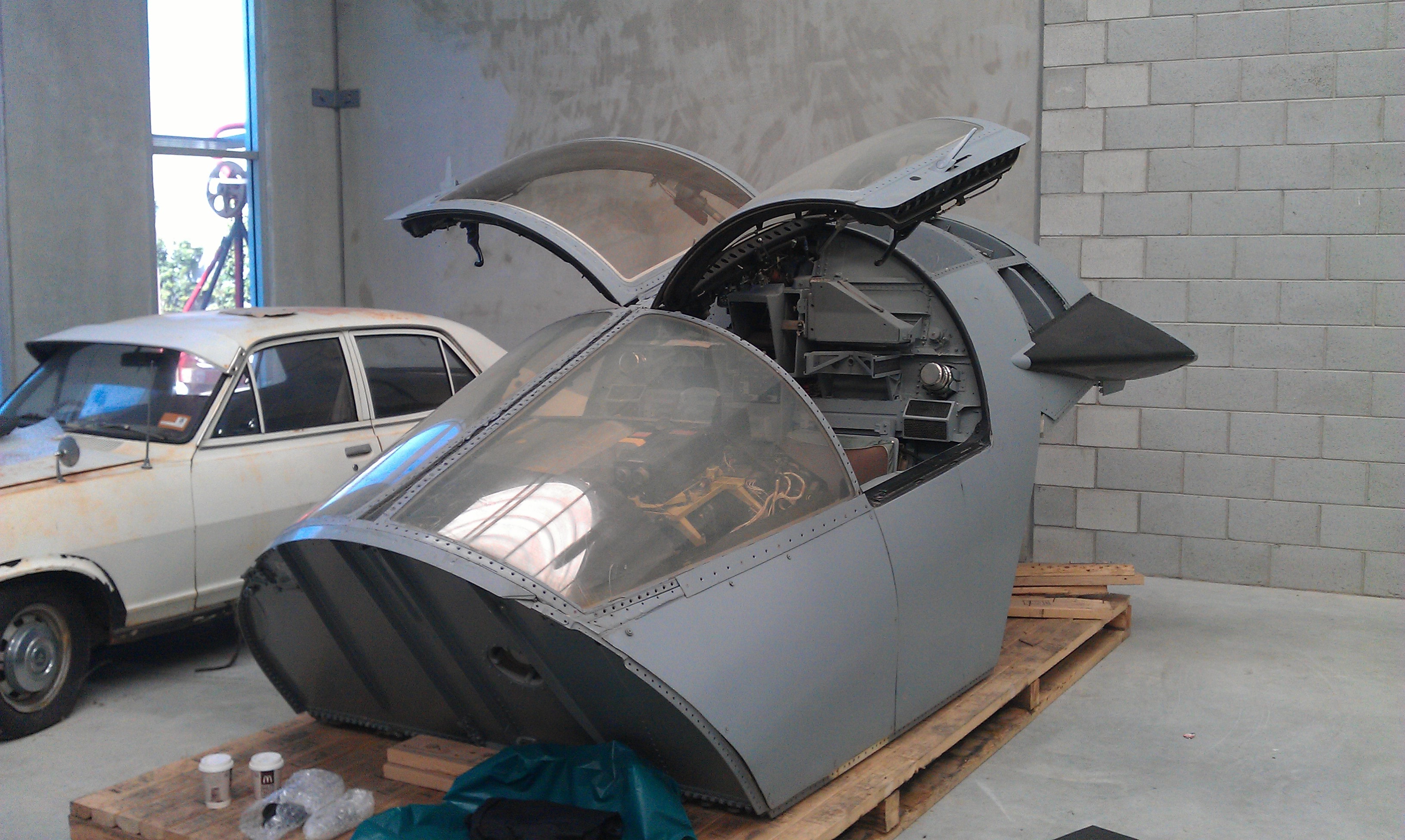 Reassembled crew module in the workshop with canopy doors raised and major exterior sections fitted