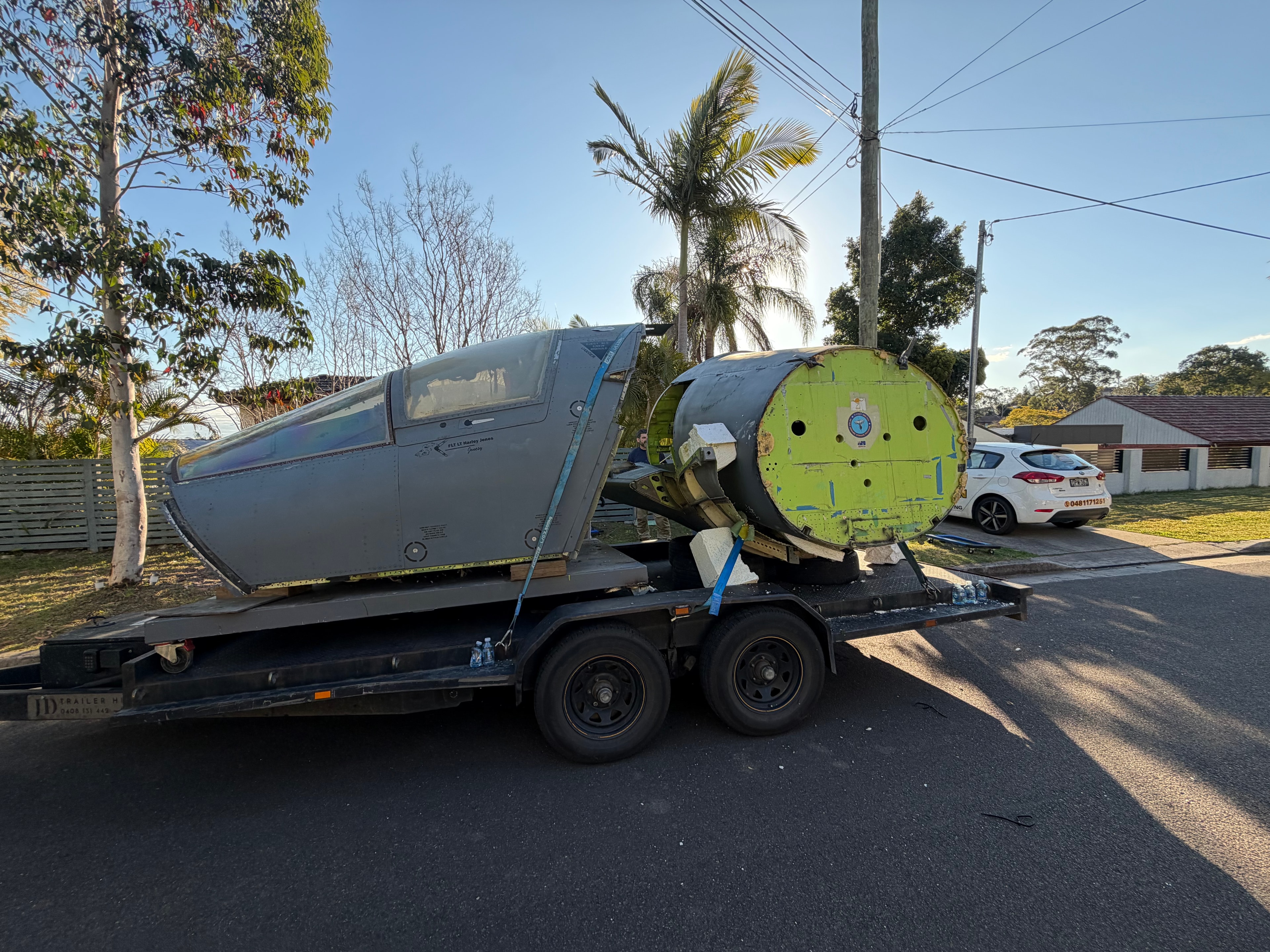 F-111 crew module secured on trailer in Sydney street, blue straps visible