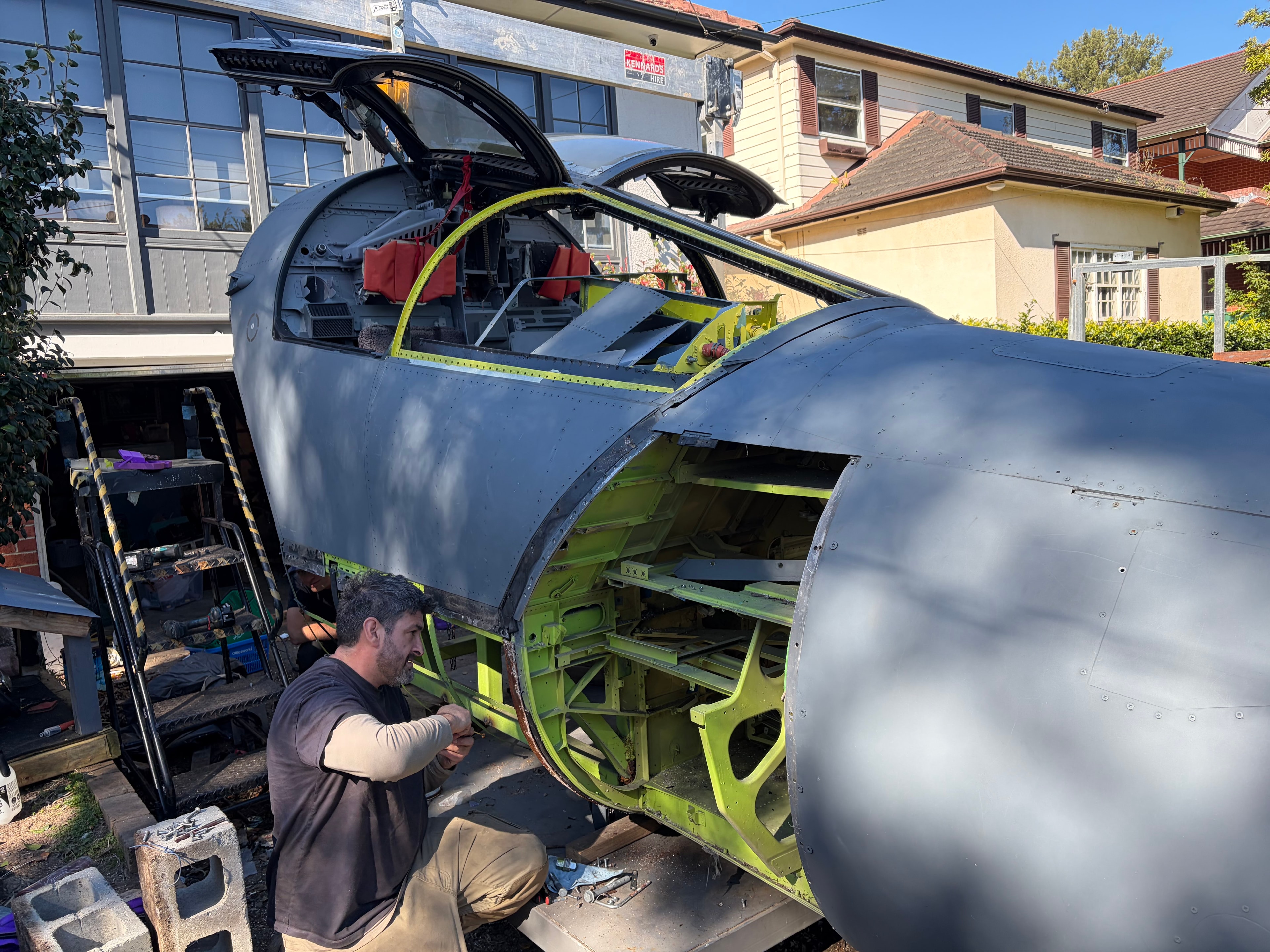 Team working on F-111 crew module exterior before transport